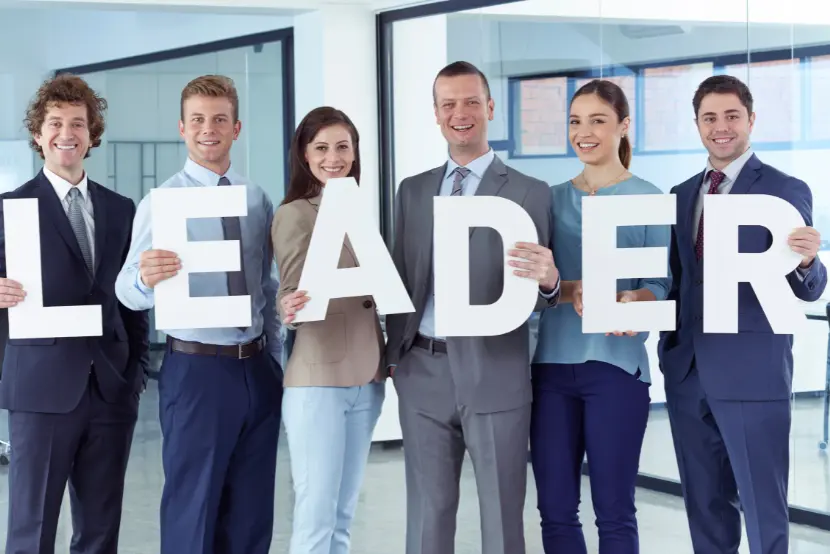 Recruiters holding letters spelling LEADER – symbolizing leadership hiring and talent search